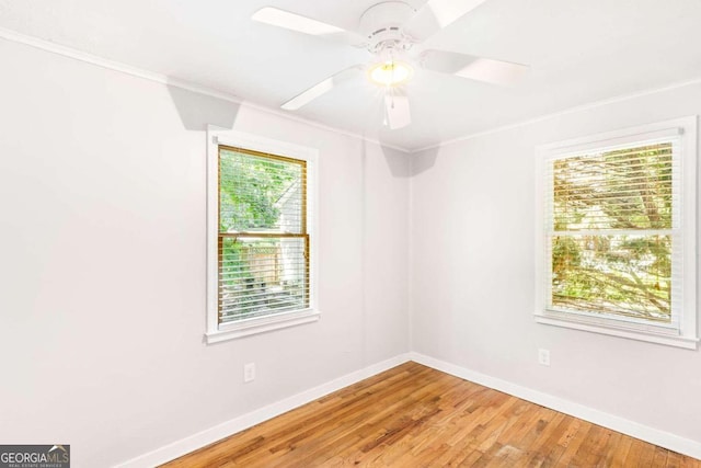 empty room featuring a wealth of natural light, hardwood / wood-style floors, and ceiling fan