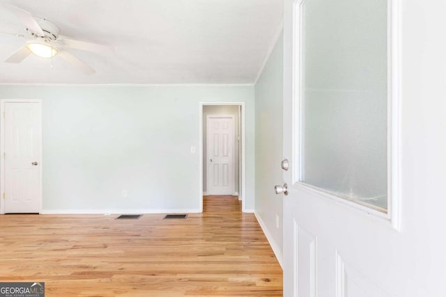 unfurnished room featuring ceiling fan, light hardwood / wood-style floors, and ornamental molding