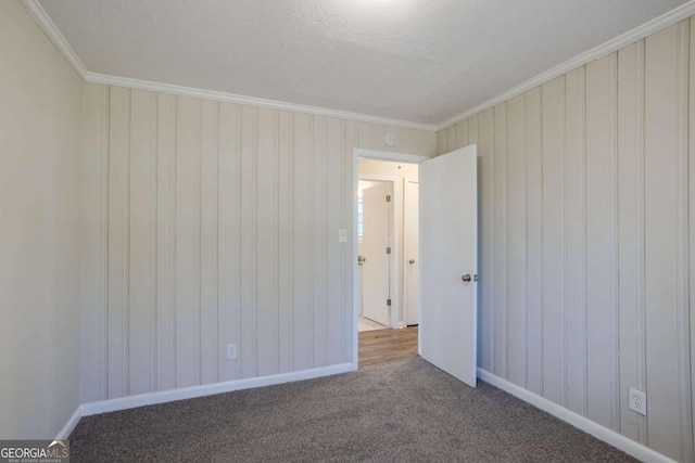 carpeted spare room with a textured ceiling and crown molding