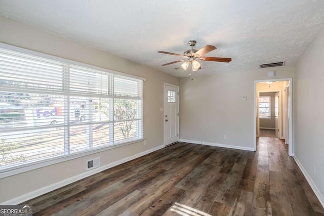 unfurnished room with a textured ceiling, dark hardwood / wood-style floors, and ceiling fan