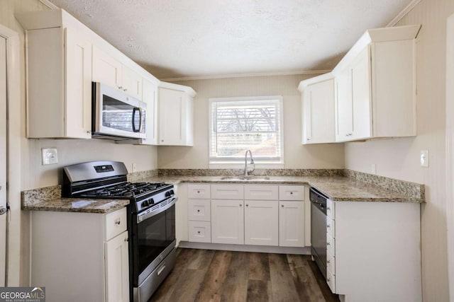 kitchen with white cabinetry, sink, dark wood-type flooring, a textured ceiling, and appliances with stainless steel finishes