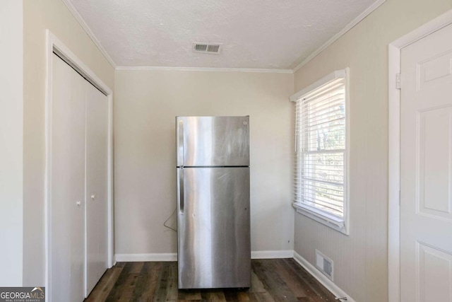 kitchen featuring stainless steel refrigerator, dark wood-type flooring, a textured ceiling, and ornamental molding