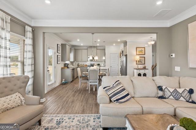 living room with crown molding and light hardwood / wood-style flooring