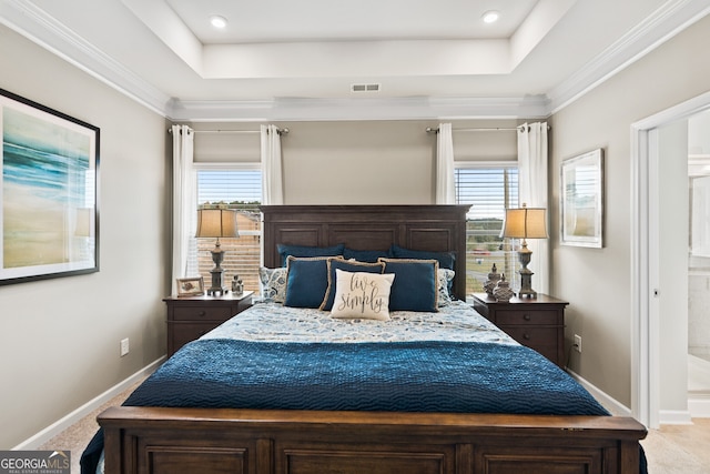 carpeted bedroom featuring a tray ceiling, multiple windows, ensuite bathroom, and ornamental molding