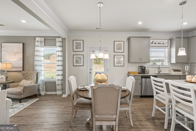 dining area with crown molding, sink, and dark hardwood / wood-style floors