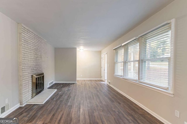 unfurnished living room featuring a fireplace and dark wood-type flooring