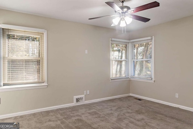 carpeted spare room featuring ceiling fan and a healthy amount of sunlight