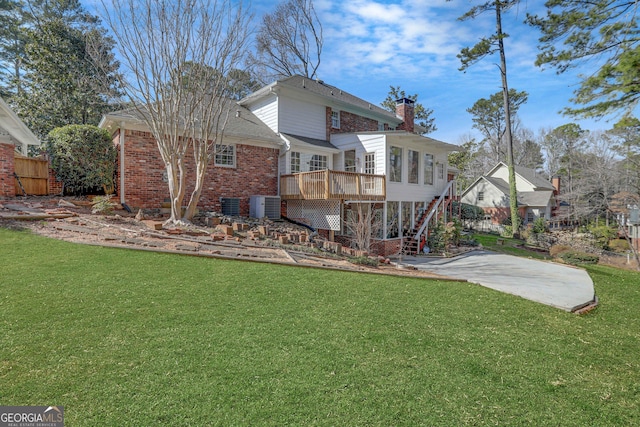 rear view of property with a lawn, a patio area, a wooden deck, and cooling unit