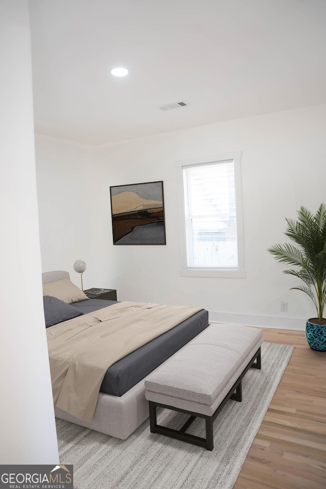 bedroom with baseboards, visible vents, wood finished floors, and recessed lighting