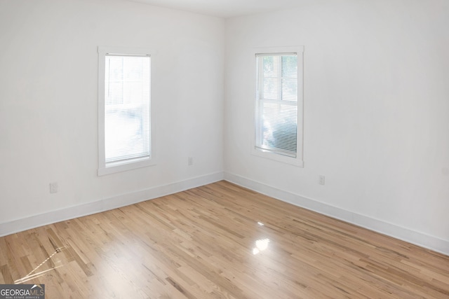 spare room with light wood-type flooring and baseboards