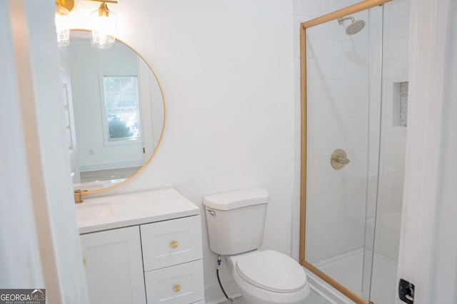 bathroom with a stall shower, vanity, and toilet