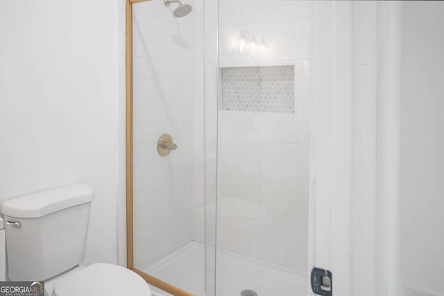 bathroom featuring a stall shower and toilet