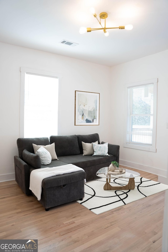 living room with light hardwood / wood-style flooring and an inviting chandelier