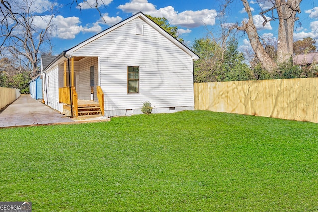 view of side of property featuring crawl space, a patio area, fence, and a lawn