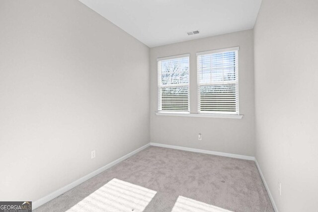 spare room featuring light colored carpet