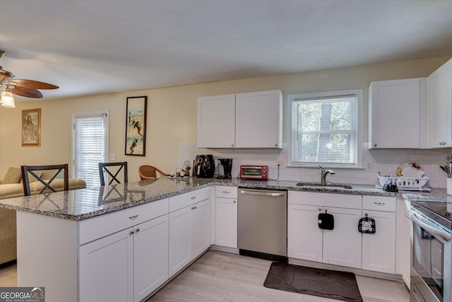 kitchen featuring white cabinets, sink, kitchen peninsula, and stainless steel appliances