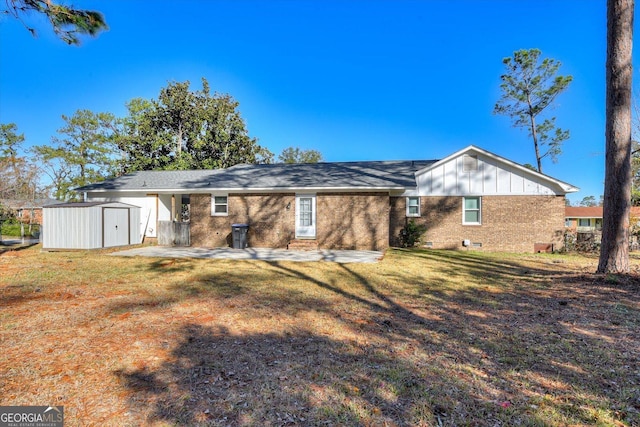 back of property featuring a storage shed and a lawn