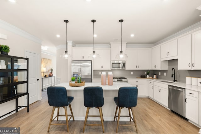 kitchen featuring a center island, white cabinets, stainless steel appliances, and light hardwood / wood-style flooring