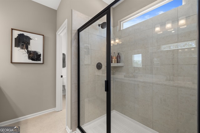 bathroom featuring tile patterned floors, toilet, and an enclosed shower