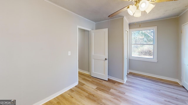 interior space featuring ceiling fan, crown molding, light hardwood / wood-style floors, and a textured ceiling