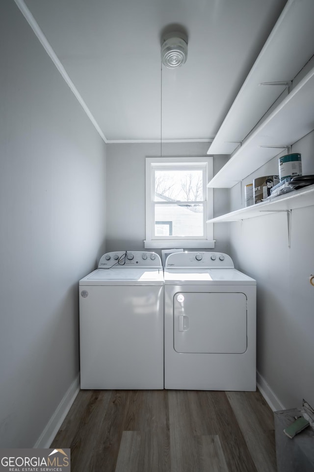 washroom with dark hardwood / wood-style flooring, washer and clothes dryer, and ornamental molding