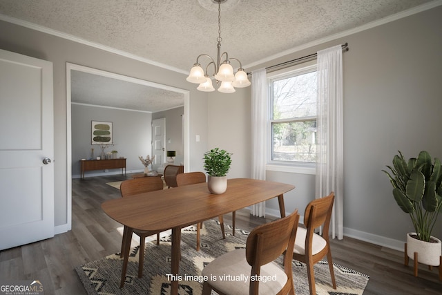 dining area with dark hardwood / wood-style floors, a chandelier, a textured ceiling, and ornamental molding