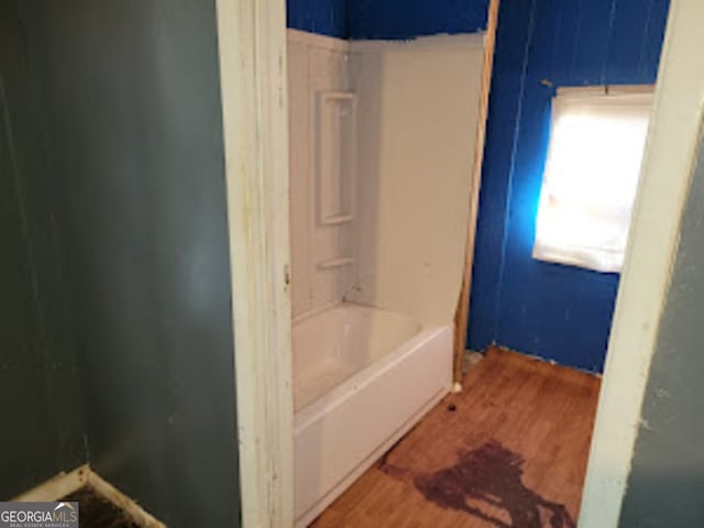 bathroom with hardwood / wood-style flooring and a washtub