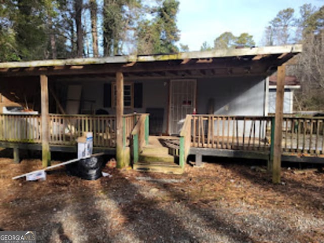 rear view of property featuring a wooden deck