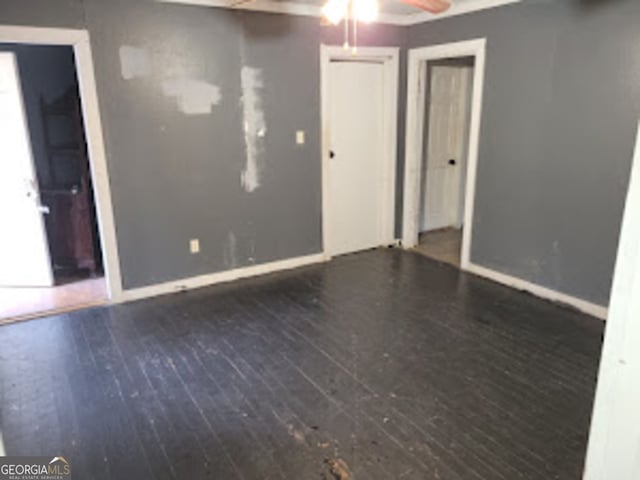 empty room featuring ceiling fan and dark hardwood / wood-style floors