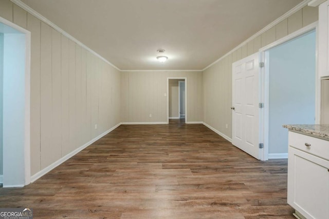 spare room with wood-type flooring and crown molding