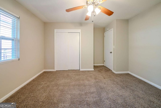 unfurnished bedroom featuring multiple windows, ceiling fan, a closet, and carpet