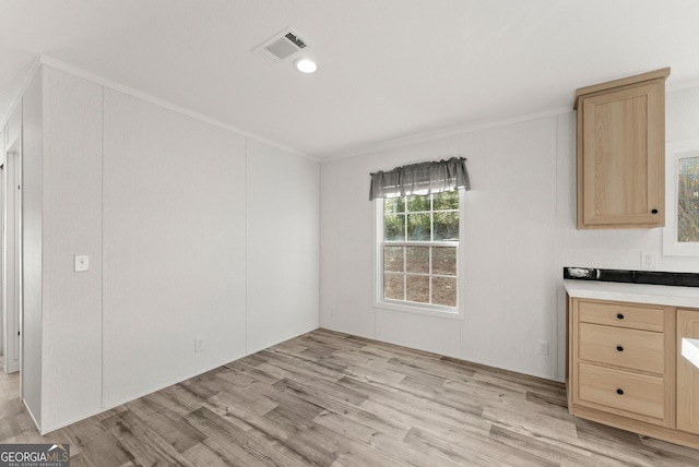 unfurnished dining area with light hardwood / wood-style floors and ornamental molding