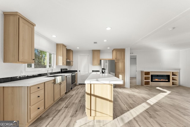 kitchen featuring sink, light hardwood / wood-style flooring, light brown cabinetry, a kitchen island, and appliances with stainless steel finishes