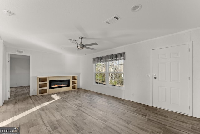 unfurnished living room with ceiling fan, light hardwood / wood-style floors, and crown molding