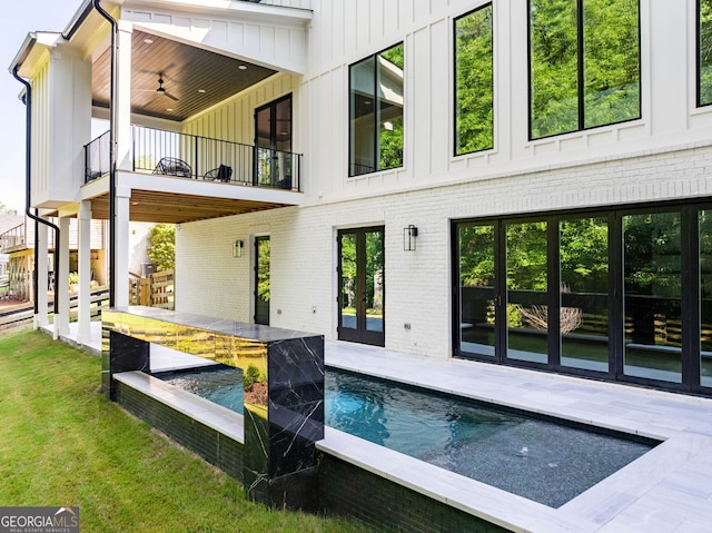 back of property featuring ceiling fan, a balcony, and a patio