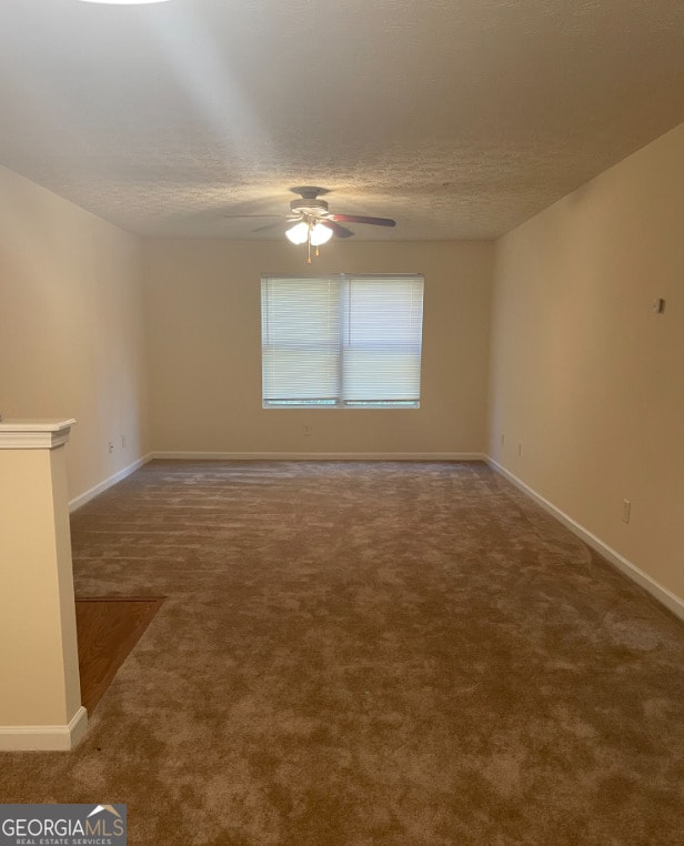 spare room featuring carpet, ceiling fan, and a textured ceiling