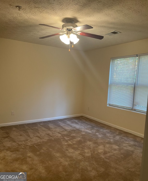 unfurnished room with carpet flooring, ceiling fan, and a textured ceiling