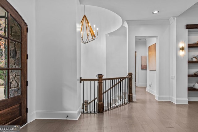 foyer entrance featuring hardwood / wood-style flooring and a notable chandelier