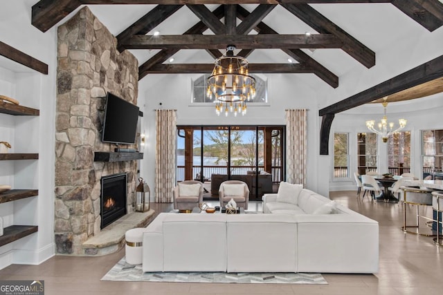 living room with a fireplace, a chandelier, high vaulted ceiling, and light hardwood / wood-style floors