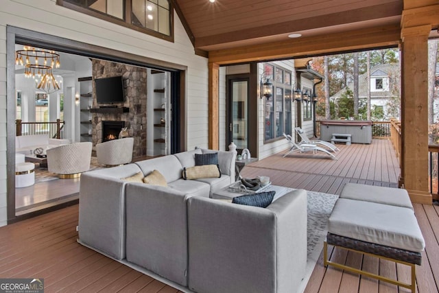 wooden terrace with an outdoor living space with a fireplace and a hot tub