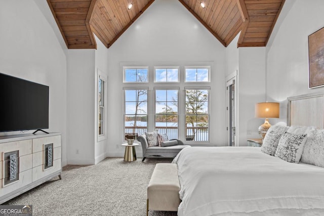 bedroom with carpet flooring, a water view, wooden ceiling, and a towering ceiling