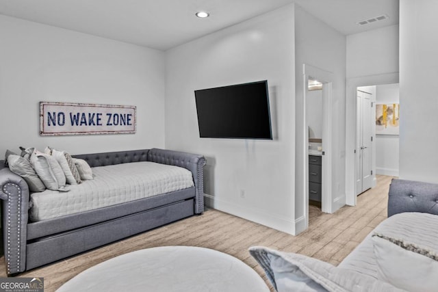 bedroom featuring light hardwood / wood-style floors and ensuite bathroom