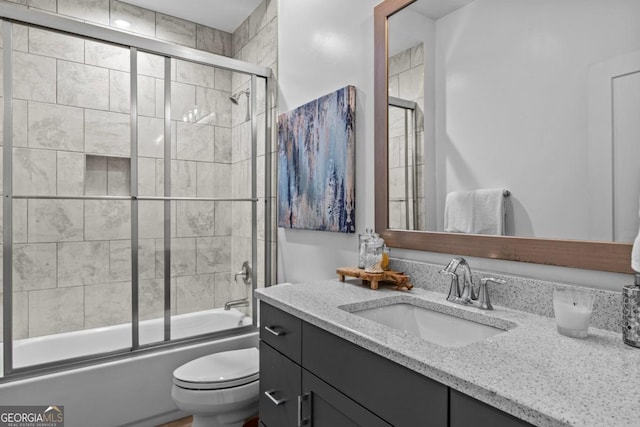 full bathroom with vanity, toilet, and bath / shower combo with glass door