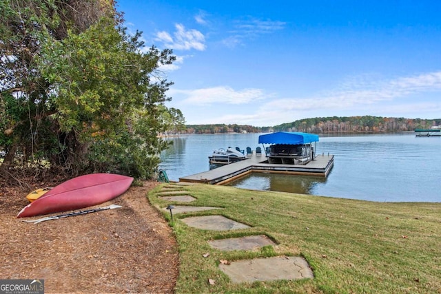 view of dock featuring a water view and a yard