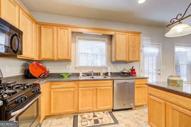 kitchen featuring a sink, light brown cabinetry, a wealth of natural light, and stainless steel appliances