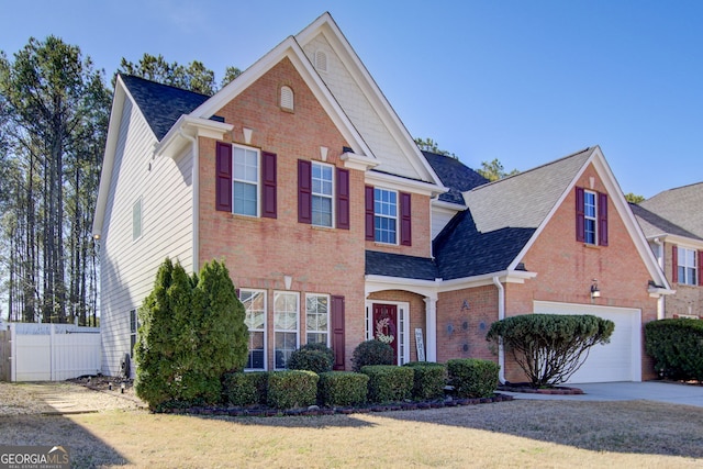 traditional-style house with concrete driveway, a garage, fence, and brick siding