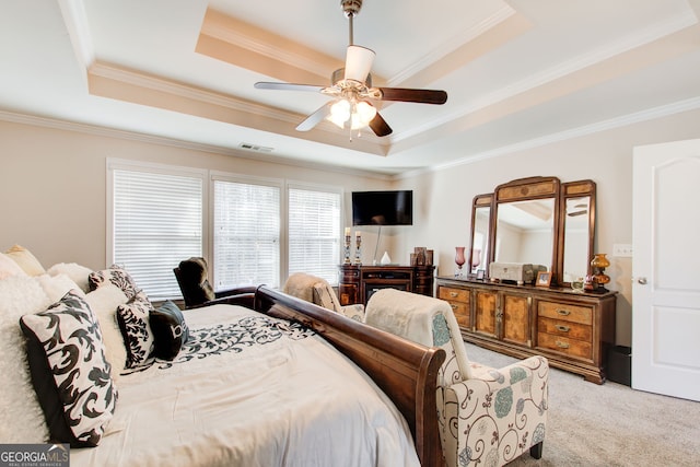 bedroom with visible vents, ornamental molding, a tray ceiling, light colored carpet, and ceiling fan