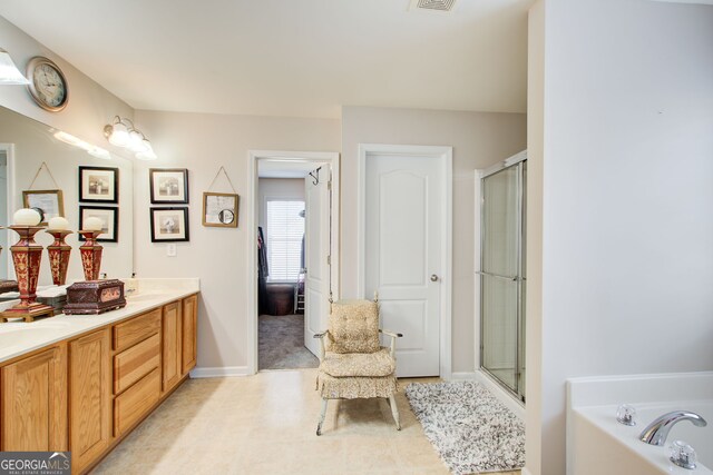 bathroom featuring double vanity, visible vents, a bathing tub, and a shower with shower door