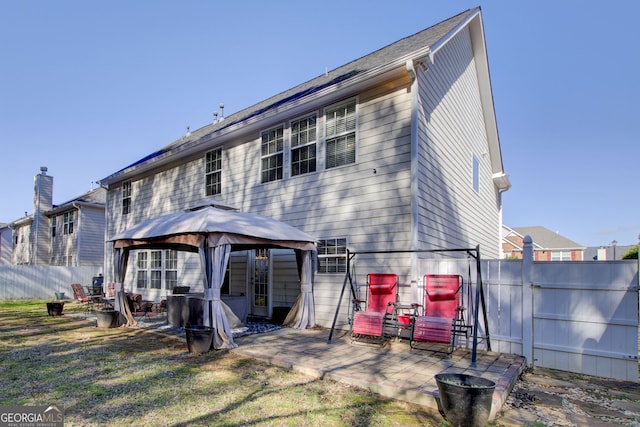 back of property featuring a gazebo, fence, and a patio area