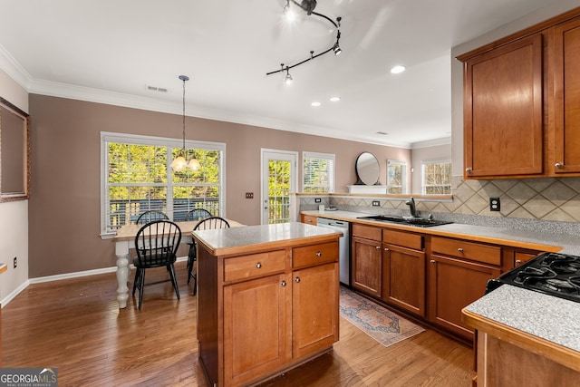 kitchen with dishwasher, decorative light fixtures, tasteful backsplash, sink, and hardwood / wood-style flooring